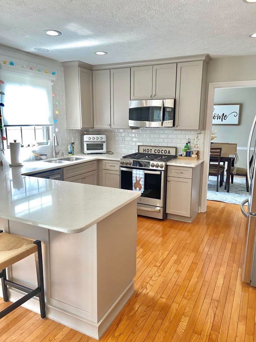 Kitchen with a quartz peninsula and hardwood floors